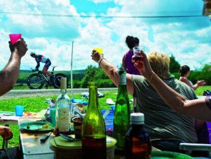 Aficionados apostados en los arcenes de la carretera disfrutan del Tour de Francia.