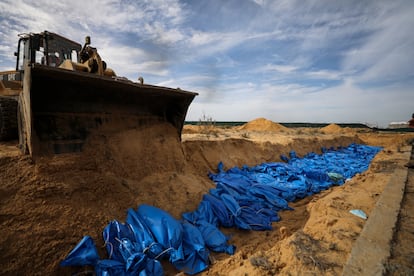 Una excavadora entierra en una fosa común a los 111 cuerpos que han sido transportados a Jan Yunis este miércoles. 