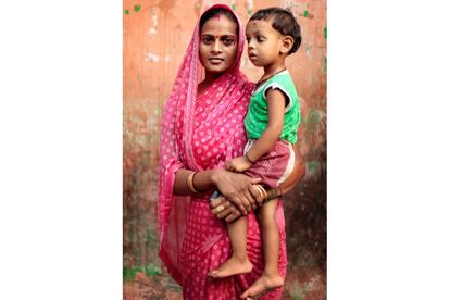 Ruby, de 28 años, sostiene en brazos a su hijo durante una visita al centro de salud del suburbio de Anna Nagar, en Nueva Delhi. Rubi tiene dos hijos y estuvo siguiendo un tratamiento para curarse de tuberculosis durante seis meses. Ya está recuperada.
