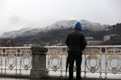 Un home observa la neu caiguda a Sant Sebastià.