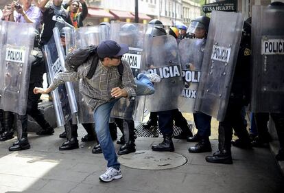 Manifestantes se enfrentan con la policía antidisturbios durante la protesta contra el programa de reformas. La policía lanzó gas lacrimógeno contra los manifestantes que lanzaron piedras y bombas incendiarias, dejando algunos oficiales heridos y varias personas detenidas durante la manifestación.