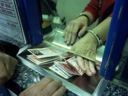 Un home compra diversos d&egrave;cims de la Loteria de Nadal.