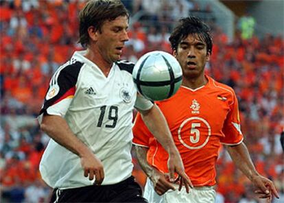 El alemán Schneider, (izqda.) y Van Bronckhorst miran al <i>roteiro</i>.