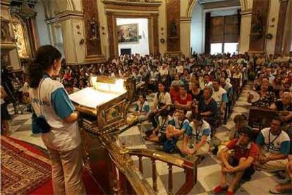 Voluntarios del V Encuentro Mundial de las Familias rezan un rosario en la basílica de la Virgen de los Desamparados.