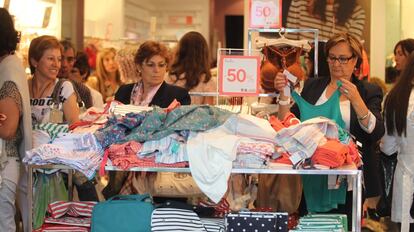 Mujeres compran ropa en una tienda.