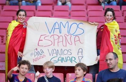 Dos aficionadas posan con una pancarta de apoyo a España, momentos antes del inicio del encuentro.