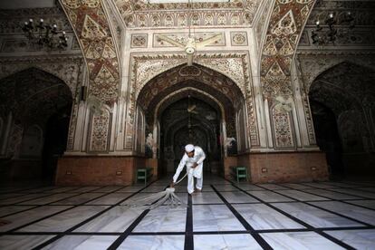 Un hombre limpia el suelo de una mezquita con miras a la celebración musulmana del Ramadán, mes sagrado de ayuno diario en Pesahwar (Pakistán).