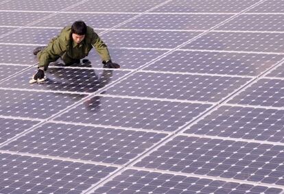 Un trabajador limpia un techo de paneles solares en Tiayuan.