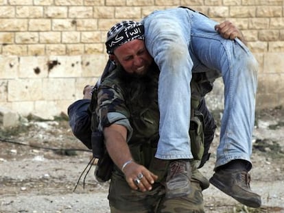Un miliciano del Ejército Libre de Siria traslada el cadáver de un compañero, el sábado.