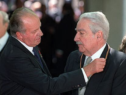 El rey Juan Carlos impone a Álvaro Mutis la medalla que le acredita como premio Cervantes.