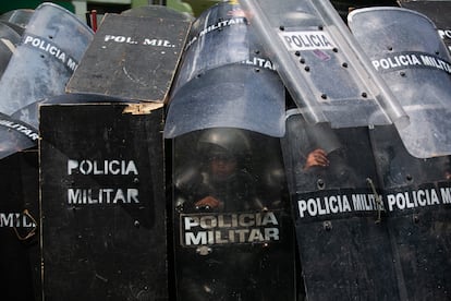 Policías se resguardan durante una protesta por el esclarecimiento de la desaparición de los 43 estudiantes normalistas de Ayotzinapa, el 23 de septiembre en Ciudad de México.