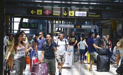 Viajeros en el área de las estaciones de Metro y Cercanías de la Terminal 4 de Barajas.