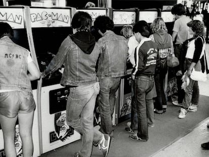 Un grupo de jóvenes juega con máquinas recreativas a principios de los ochenta. 