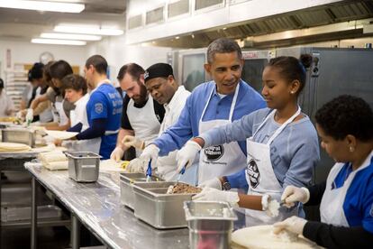 Barack Obama y su hija Sasha sirviendo burritos durante el día de Martin Luther King, en un enero de 2014.