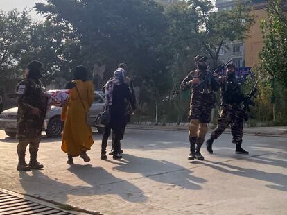 Varios talibanes quitan la pancarta a las mujeres que se manifestaban y alejan a los periodistas del lugar, este jueves en Kabul