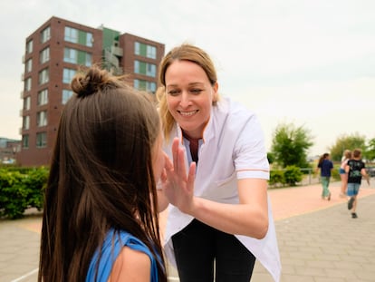 La dermatóloga Karen van Poppelen pone crema a una niña en un colegio holandés.