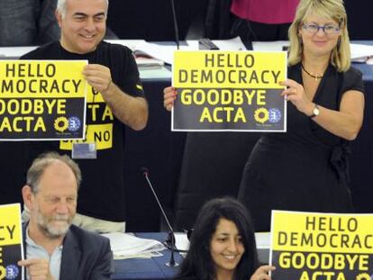 Eurodiputados de Los Verdes muestran carteles con el mensaje &quot;Hola democracia. Adi&oacute;s Acta&quot;.