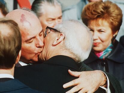 Soviet President Mikhail Gorbachev (l) hugs East German State and Party leader Erich Honecker after Gorbachev's arrival at East Berlin Schoenefeld airport, 6. October 1989. On the right is Raisa Gorbachev. The Soviet President will attend festivities marking the 40th anniversary of the GDR. (AP-Photo/Boris Yurchenko)