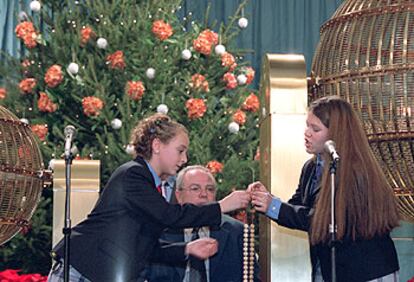 Dos niñas del colegio de San Ildefonso cantan los números de la Lotería de Navidad de 2002.