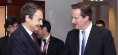 José Luis Rodríguez Zapatero y David Cameron se saludan el 17 de junio en una cumbre de líderes europeos.