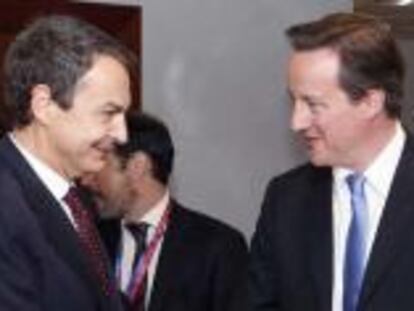 José Luis Rodríguez Zapatero y David Cameron se saludan el 17 de junio en una cumbre de líderes europeos.