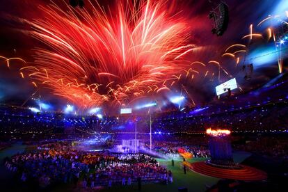 Los fuegos articiales estallan en distintos colores en el estadio olímpico sobre las delegaciones participantes.