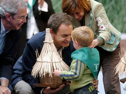 José Luis Rodríguez Zapatero; el candidato del PSdeG a la Xunta de Galicia, Emilio Pérez Touriño, y la ministra de Agricultura y Pesca, Elena Espinosa, saludan a un niño ayer en Santiago de Compostela.