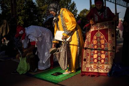 Mujeres musulmanas instalan su alfombra de oración para asistir a una oración matutina en el páramo industrial de Parco Dora, en Turín (Italia).