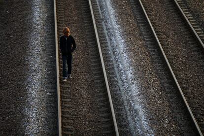 Un inmigrante por las vías ferroviarias antes de intentar tomar un tren con destino hacia Reino Unido.