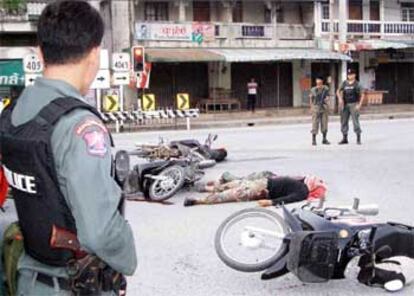 Un policía tailandés contempla el cuerpo sin vida de un rebelde musulmán abatido en Yala.