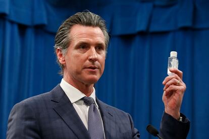 El gobernador de California, Gavin Newsom, muestra un bote de gel desinfectante en una conferencia de prensa, este miércoles en Sacramento.