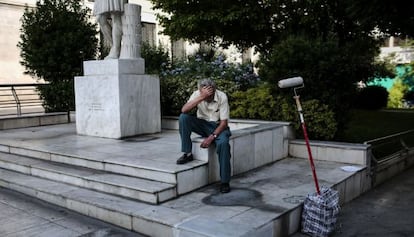 Un pintor espera a lograr clientes, en el centro de Atenas.