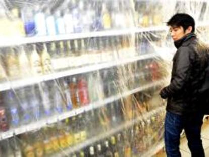 Un vendedor cubre los estantes con licores fuertes el pasado 14 de septiembre de 2012, en una tienda de Praga (R. Checa), después de que el Ministerio checo de Sanidad prohibiera, con efecto inmediato y por tiempo indefinido, la venta de licores con más del 20 % de alcohol.