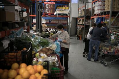 Voluntarios de Caritas preparan lotes de comida para usuarios del barrio del Eixample de Barcelona.