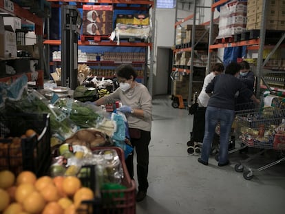 Voluntarios de Caritas preparan lotes de comida para usuarios del barrio del Eixample de Barcelona.