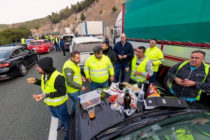 Un grupo de agricultores almuerza mientras sus tractores mantienen cortada la autovía A-30 a la altura del puerto de la Cadena, en dirección a Murcia.