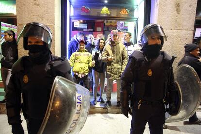 Unos jóvenes gesticulan mientras esperan en un local que se calmen los disturbios producidos en la Puerta del Sol durante una protesta en apoyo al barrio de Gamonal en Burgos.