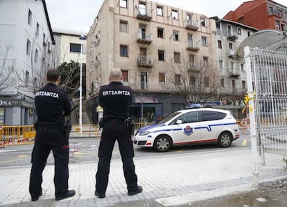 Dos 'ertzainas' vigilan los inmuebles de Trintxerpe afectados por el incendio.