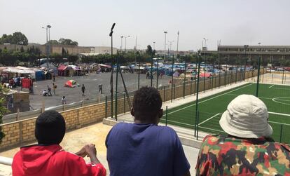 Tres subsaharianos observan desde un puente el campamento donde viven en Casablanca.