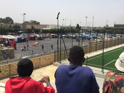 Tres subsaharianos observan desde un puente el campamento donde viven en Casablanca.