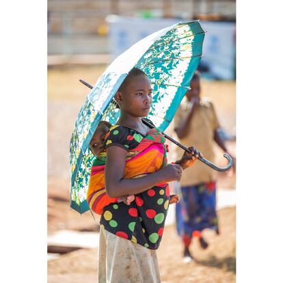 Una niña carga en su espalda a su hermana pequeña, en el campamento de refugiados de Kigoma.