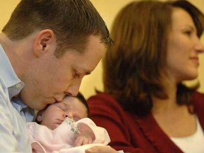 El padre de Grace VanDerwerken, Jay VanDerwerken, le da un beso mientras que la madre da una rueda de prensa en el Hospital Infantil de Boston.