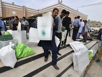 Personal electoral de Pakistán transporta material en vísperas de los comicios, en Karachi, este miércoles.