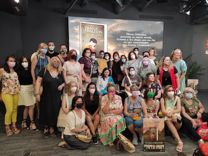 La escritora Diana Gabaldon, sentada en el centro con una prenda azul y sin mascarilla, posa junto a sus lectoras tras la presentación de su nuevo libro.