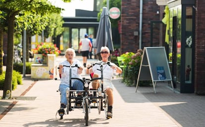 Una anciana pasea junto a un cuidador en las calles de la residencia para enfermos con alzhéimer de Hogeweyk (Holanda).
