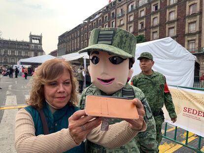 Tras la celebración, unos pocos se han quedado a celebrar en el Zócalo capitalino. En la imagen, una mujer se toma una fotografía con una botarga de un soldado del Ejército Mexicano.