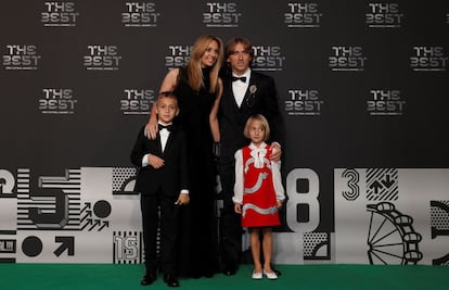 El jugador croata del Real Madrid Luka Modric posa junto a su familia en la alfombra verde antes del inicio de la gala.
