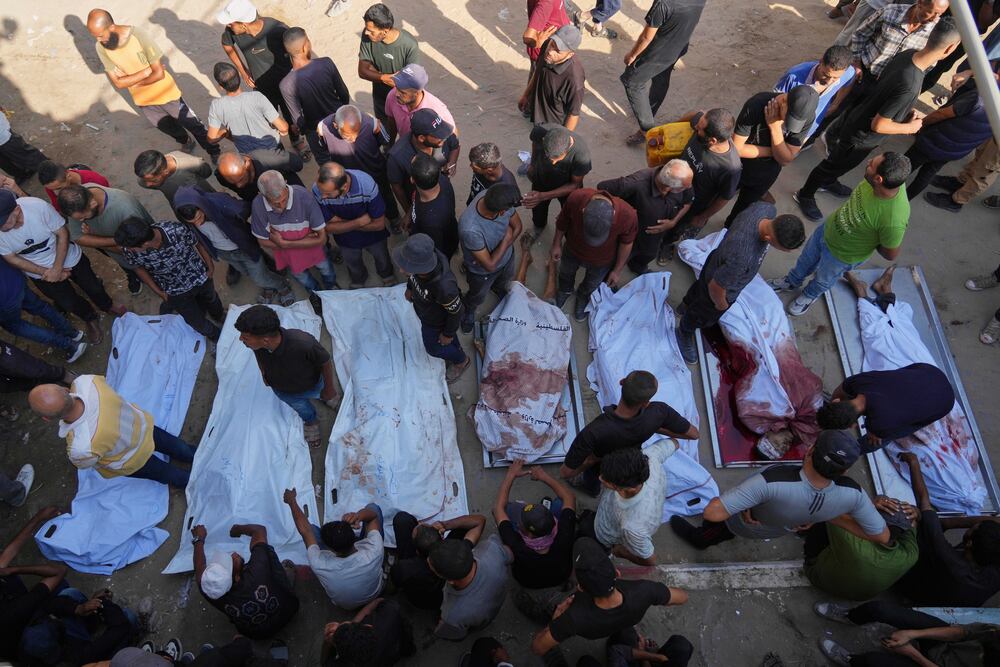 Palestinians mourn over the bodies of people killed either by Israeli military strikes or while trying to reach aid trucks, outside Shifa Hospital, in Gaza City, Thursday, Aug. 21, 2025. (AP Photo/Jehad Alshrafi)






