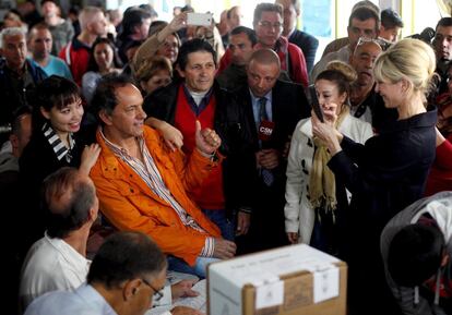 Daniel Scioli, gobernador de la provincia de Buenos Aires y candidato presidencial, posa para una foto con su esposa Karina Rabolini, después de emitir su voto.