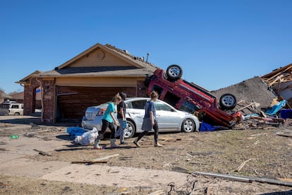 Neighbors walk in front of a home damaged at Wheatland Drive and Conway Drive on Monday, Feb. 27, 2023 in Norman, Okla.